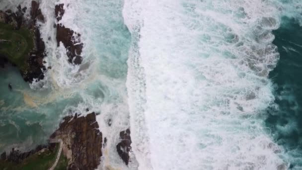 西班牙科鲁纳峡谷海滩 带泡沫波浪从悬崖上翻滚而下的汹涌大海自上而下的景象 空降飞行员中枪 — 图库视频影像