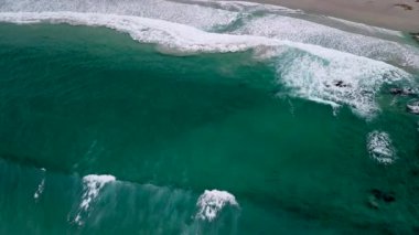 İspanya, Corua 'da gündüz vakti, Caion Beach' in havadan çekilmiş büyük dalgaları yavaşça kıyıya vuruyor. Yukarıdan aşağıya