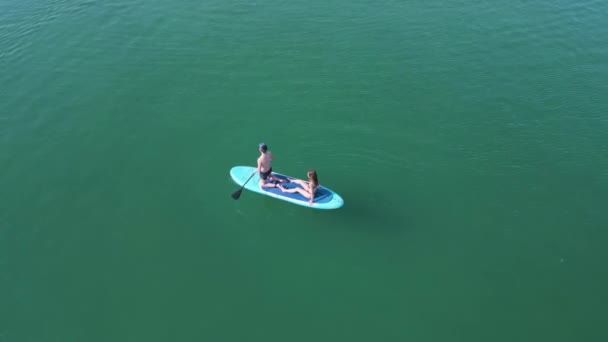 Couple Paddleboard Woman Sitting Man Kneeling Rowing Aldan Spain Aerial — Stock Video