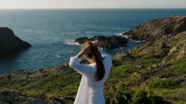 Galiçya, İspanya 'da Ferrol yakınlarında Deniz Burnu' nu incelerken Elleriyle Saçlarını Tarayan Kadın. Yavaş çekim