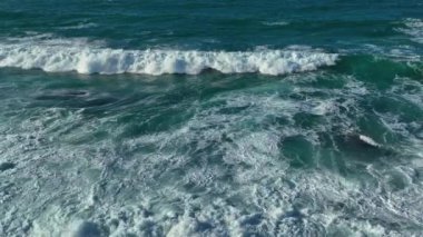 Köpüklü yüzeyde sürünen okyanus dalgalarının nefes kesici yavaş görüntüsü. Hava Görüntüsü
