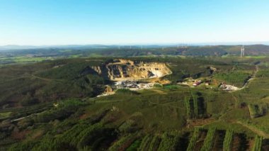 Arka planda rüzgar türbinleri olan Quarry sitesi İspanya 'nın Corua şehrinde temiz enerji üretiyor. - Havadan çekim.