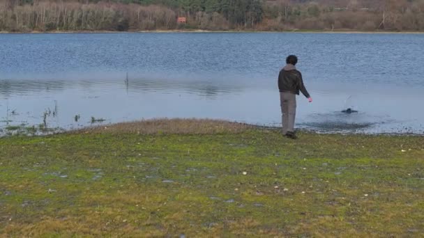 Mladý Muž Házet Kameny Jezeru Drone Shot — Stock video