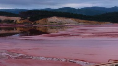 İspanya, Lugo 'da zehirli alkali atığıyla kirletilmiş kırmızı sümüklü alcoa gölü. İHA atışı