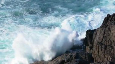 Köpüklü dalgalar, parlak güneşli bir günde Oleiros, A Coruna, Galiçya, İspanya yakınlarındaki Seixo Branco Plajı 'nda Rocky Coast' a vurur. Yavaş Hareket Görüntüsü