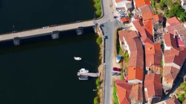 İspanya, Lugo 'da Ponte de Belesar yakınlarında Minho Nehri kıyısındaki tipik evler ve üzüm bağları. hava görüntüsü