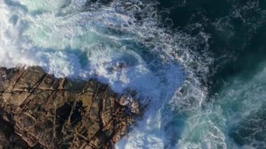 Punta Herminia Park, İspanya 'da Rocky Shore' a dalgalar çarpıyor. havadan aşağı, yavaş çekim