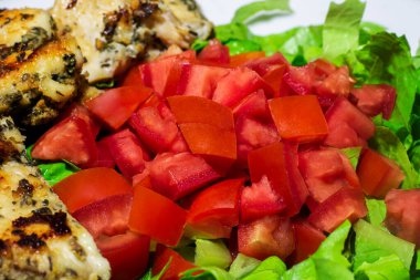 Kızarmış tavuklu domates ve marul salatası.