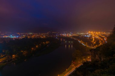 Karanlık sisli bir sonbahar akşamında şehir tepeden çöker.