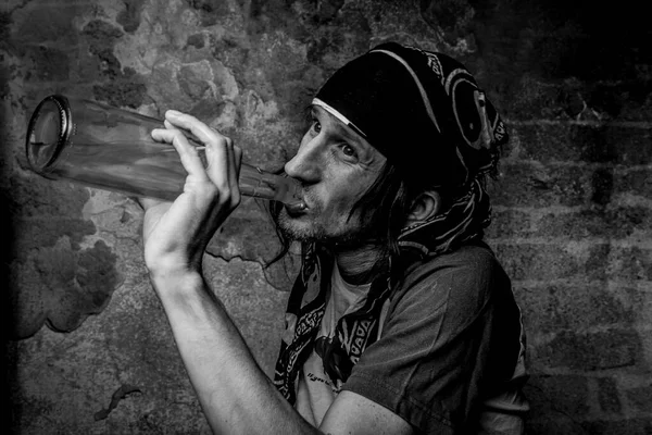 Pria Rambut Hitam Dengan Botol Alkohol Dekat Dinding Bata Tua — Stok Foto