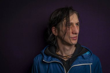 Uzun siyah saçlı adam portresi koyu renkli arka plan