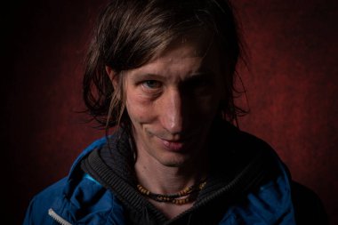 Uzun siyah saçlı adam portresi koyu renkli arka plan