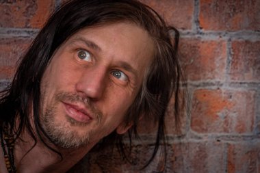 Kıllı kızıl adam eski tuğla turuncu duvarın yanında