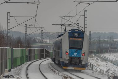 Veseli nad Luznici yakınlarındaki hızlı yolcu treni karlı platformlar ve karanlık bulutlu gökyüzü ile durdu