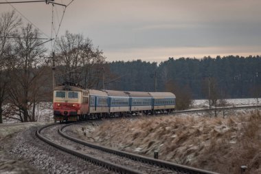 Passenger electric train in frosty cloudy winter morning near station Donov 01 30 2023