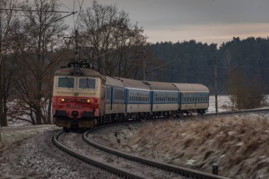 Passenger electric train in frosty cloudy winter morning near station Donov 01 30 2023