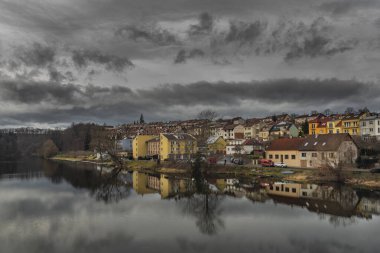 River Otava and weir with pedestrian bridge near Pisek town in south Bohemia in winter evening