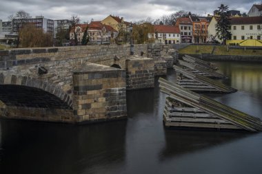 Old stone bridge and center of Pisek town in cloudy winter windy morning