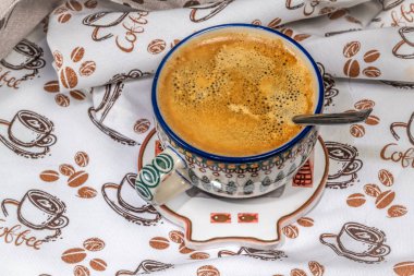 Kaşık ve fincanlı bulaşık havlusu ve şekerli kahve ve kuru süt.