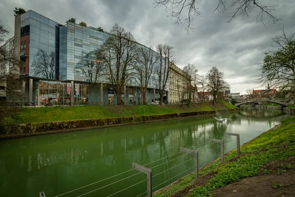 首都リュブリャナの春の曇りの日に緑の汚れた水とリュブリャナ川03 2023 — ストック写真