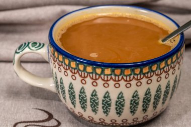 Kaşık ve fincanlı bulaşık havlusu ve şekerli kahve ve kuru süt.