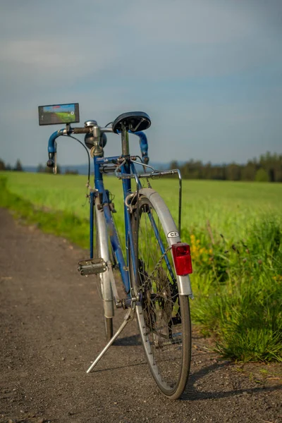 자전거와 현대적 전화를 근처의 목초지에서 — 스톡 사진
