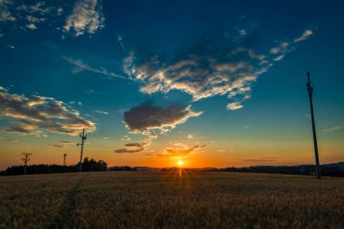 Günbatımında Roprachtice dağları yakınlarında yaz renk tahıl tarlası.