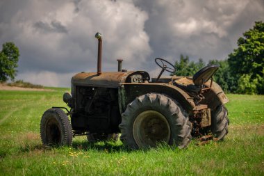 Tarlada hasat için hazır tarihi bir traktörle manzaralı bir yer.