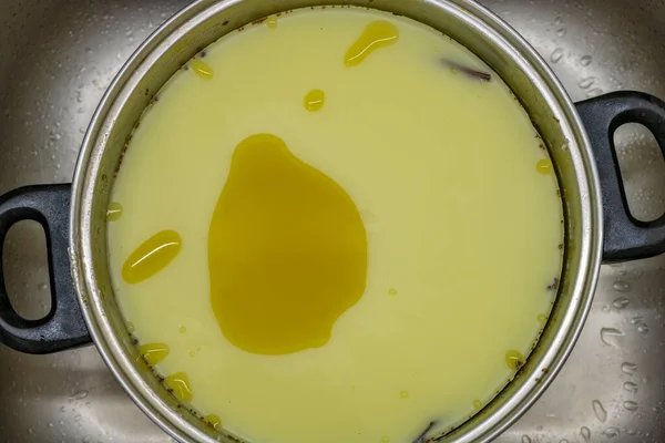 汚れたキッチンで金属調理ポットで作られたマリファナグリーンバター — ストック写真