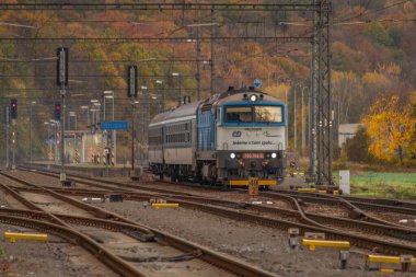 Bludov CZ 11 04 2023 'te sonbaharda küçük bir istasyon yakınında yolcu treni temiz renk günü