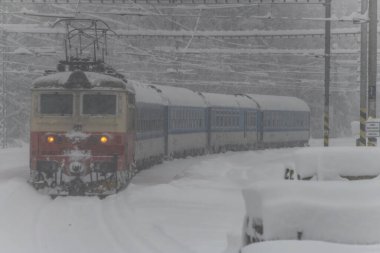 Chotycany CZ 12 02 2023 'teki derin karlı ormanın yakınındaki elektrikli trenler.