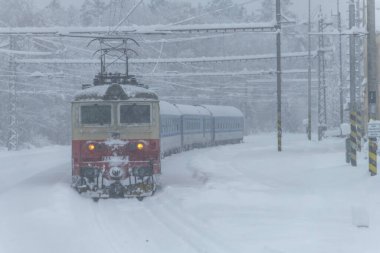 Chotycany CZ 12 02 2023 'teki derin karlı ormanın yakınındaki elektrikli trenler.