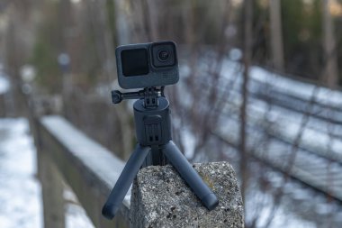 Küçük kamera ve tripod kışın güneşli bir sabah karlı dağlarda