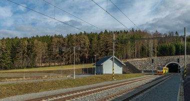 Yolcu trenleri Jesetice CZ 02 18 2024 'teki tren istasyonunda yüksek hızlı tünelin yanında duruyor.