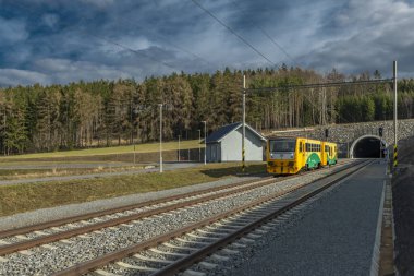 Yolcu trenleri Jesetice CZ 02 18 2024 'teki tren istasyonunda yüksek hızlı tünelin yanında duruyor.