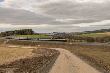 Yolcu trenleri Jesetice CZ 02 18 2024 'teki tren istasyonunda yüksek hızlı tünelin yanında duruyor.