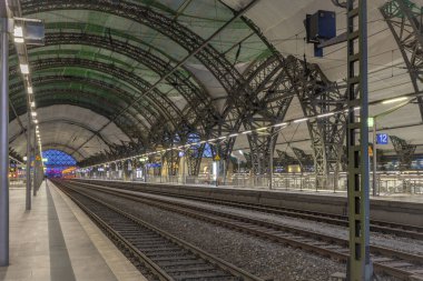 Dresden Almanya istasyonunda demiryolları ve büyük salonlarıyla güneşli bir gün batımı gecesi.
