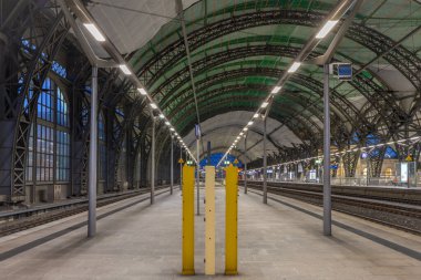 Dresden Almanya istasyonunda demiryolları ve büyük salonlarıyla güneşli bir gün batımı gecesi.