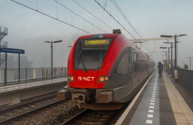 Passenger trains in morning misty railway stop in Dordrecht Stadspolders Netherlands 03 06 2024 clipart