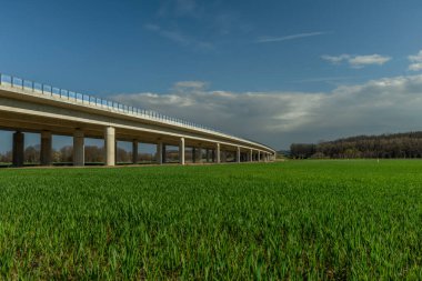 Budweis CZ yakınlarında yeşil sabah tarlası ve mavi gökyüzü olan yeni karayolu köprüsü.