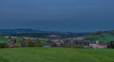 Akşam Roprachtice köyünün yakınlarında, bulutlu güneşli bir akşamda, gün batımında.