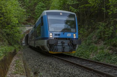 Mavi motorlu yolcu birimi Raspenava CZ 05 04 2024 yakınlarında güneşli bir günde mavi gökyüzünde tren kullanıyor.