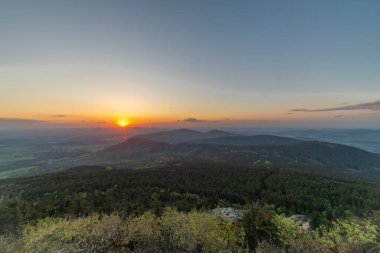 Kuzey Çek Cumhuriyeti 'nde günbatımının renklendirildiği ilkbaharda Jested tepesinden manzara