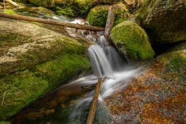 Jeleni Şelalesi ilkbaharda güneşli bulutlu bir günde taze renkli Jizerske dağlarında