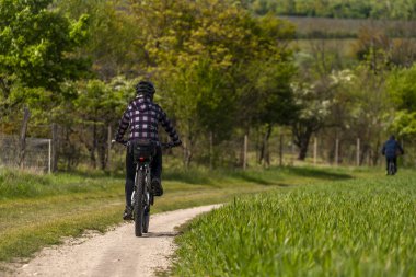 Güneşli bir bahar gününde bisiklet yolundaki kadın Mikulov CZ 04 25 2024