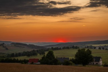 Krusne dağlarında gün batımı olan çayırlar Nova ves Horach köyünde renkli bir akşamda