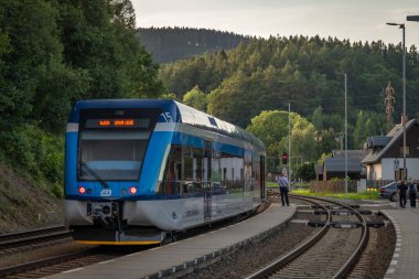 Ostruzna CZ 07 19 2024 'teki platformu ve mavi yolcu treniyle tren istasyonu.