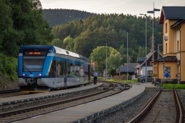 Ostruzna CZ 07 19 2024 'teki platformu ve mavi yolcu treniyle tren istasyonu.