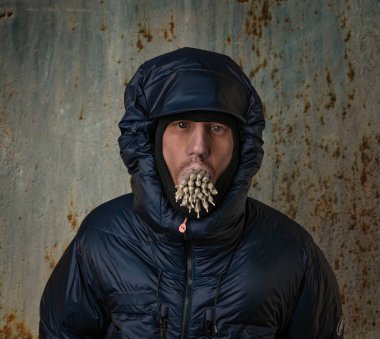 Kışlık mavi ceketli ve ağzında 29 marihuana esrarı olan beyaz adam.