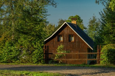 Ahşap kulübeler ve yaz sonlarındaki çayırlar güneşli bir akşamda CZ 09 20 2024